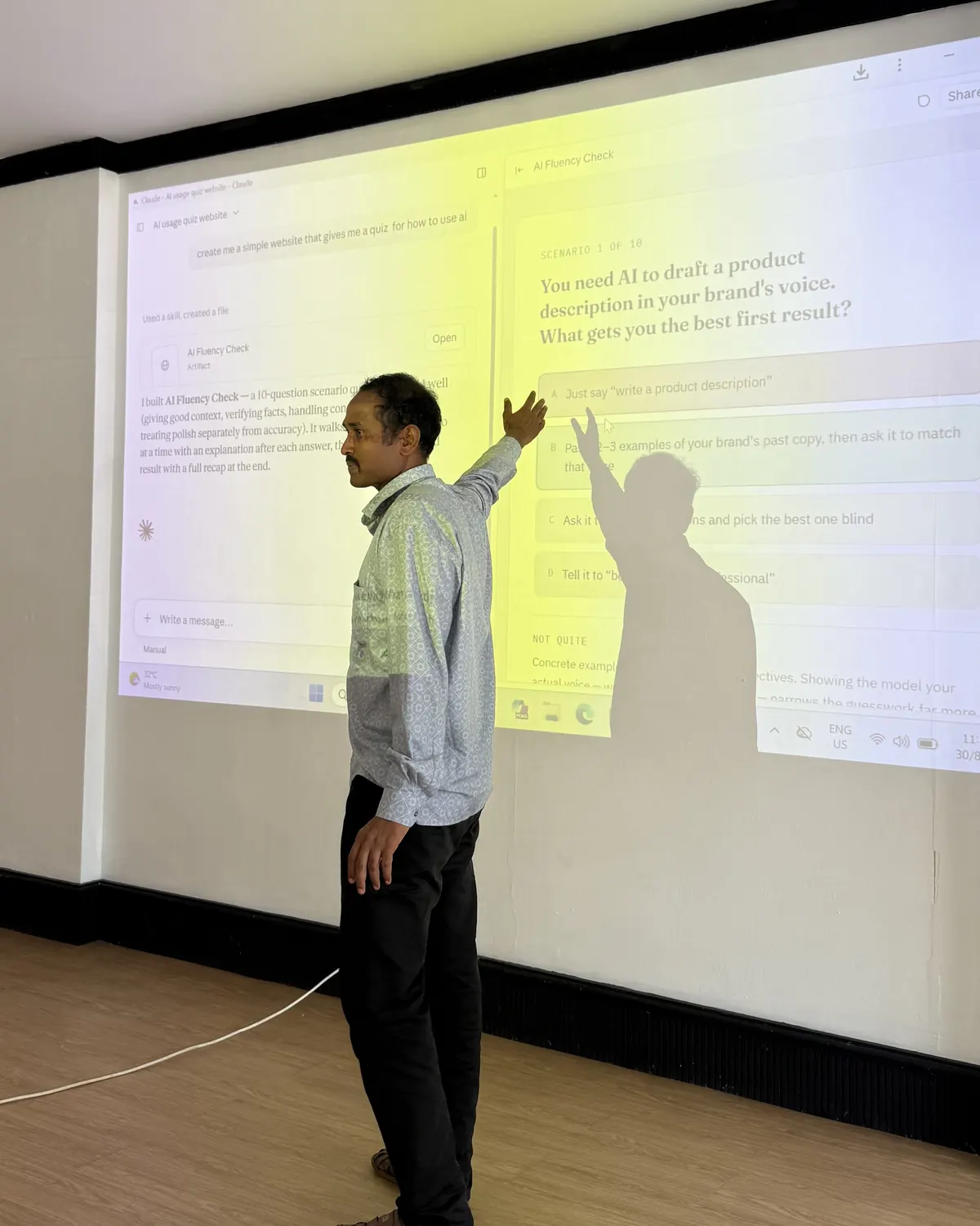 A person pointing at a prompt projected on the wall while learners watch