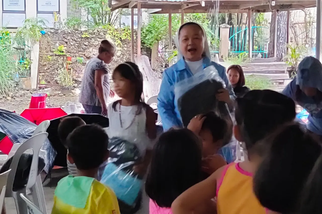Children gathered around volunteers in an open hall