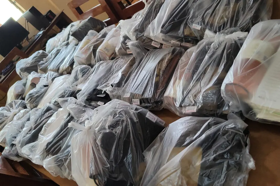 Rows of school kits wrapped in plastic on a table