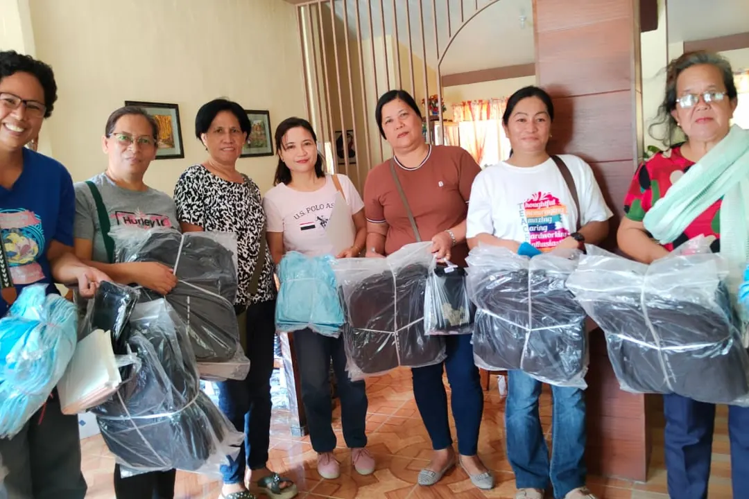 Volunteers holding school kits in a room