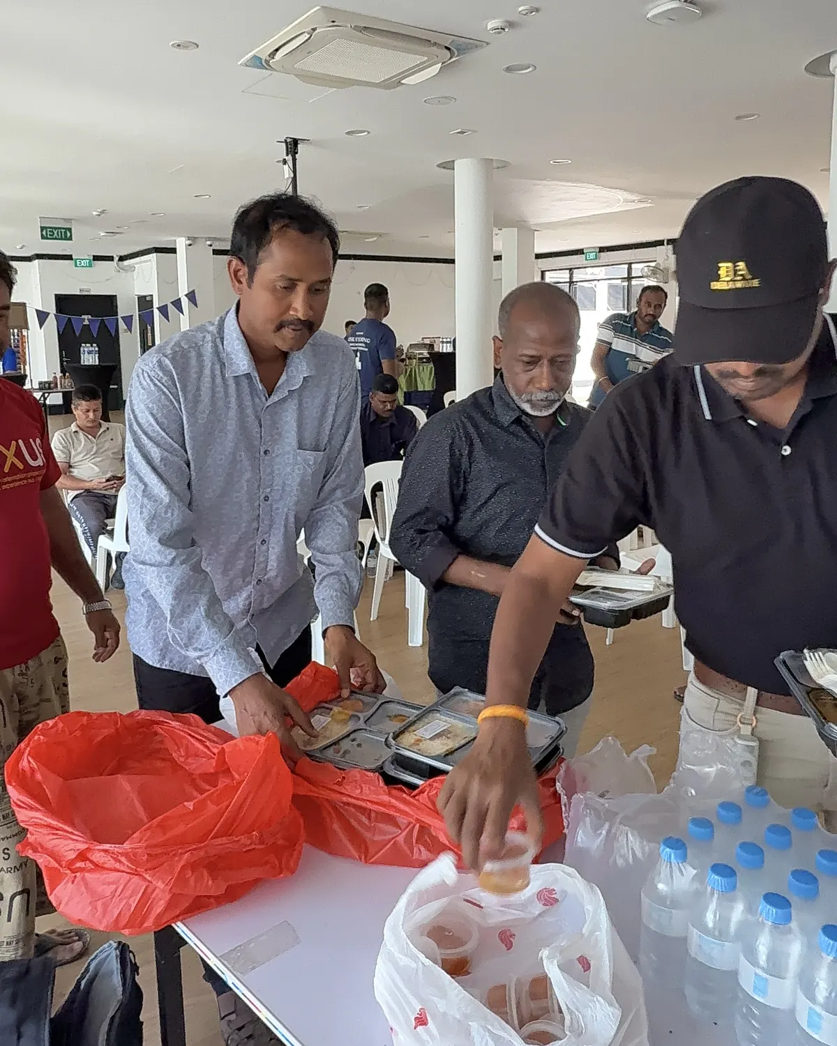 Volunteers handing out lunch and bottled water from a table