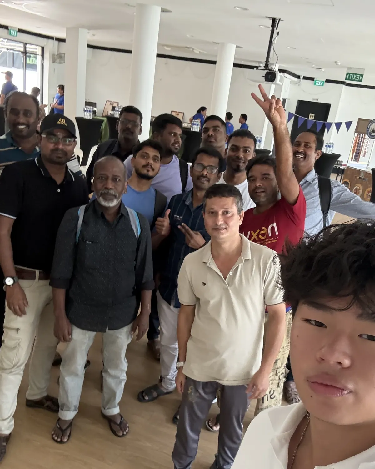 Yibo Yang taking a selfie in front of a group of learners, some waving