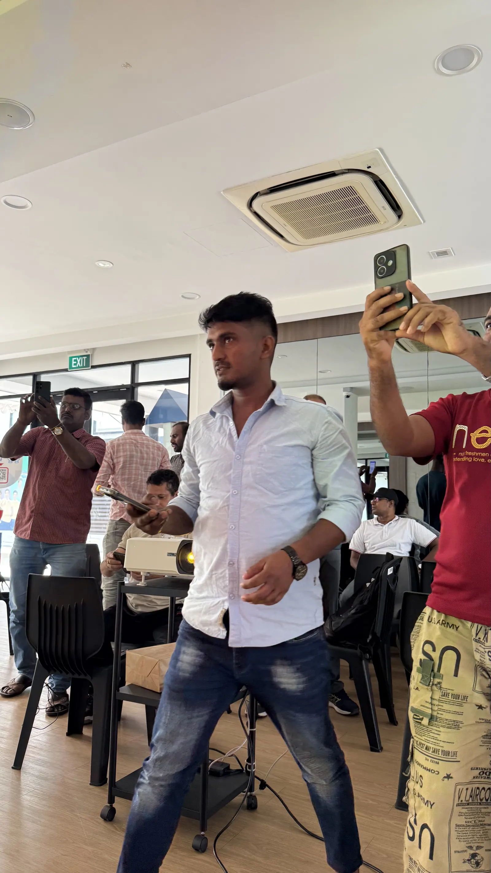 Learners standing and taking photos of a screen with their phones