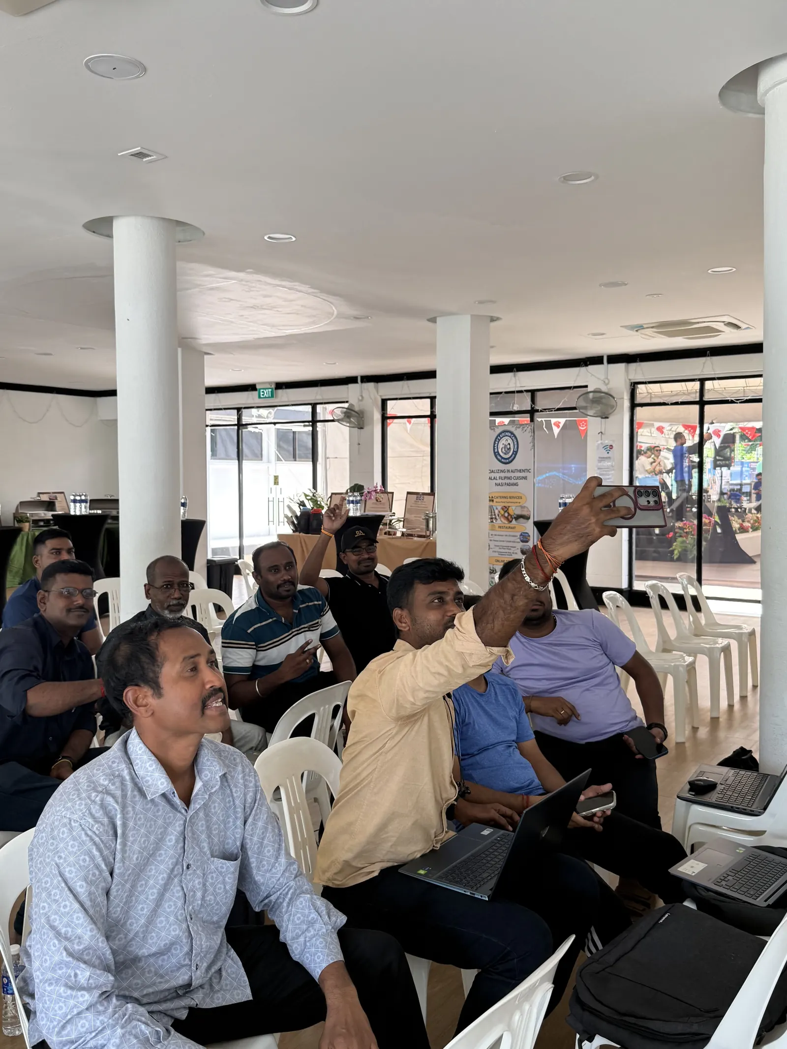 A learner raises a hand with a question while others look on