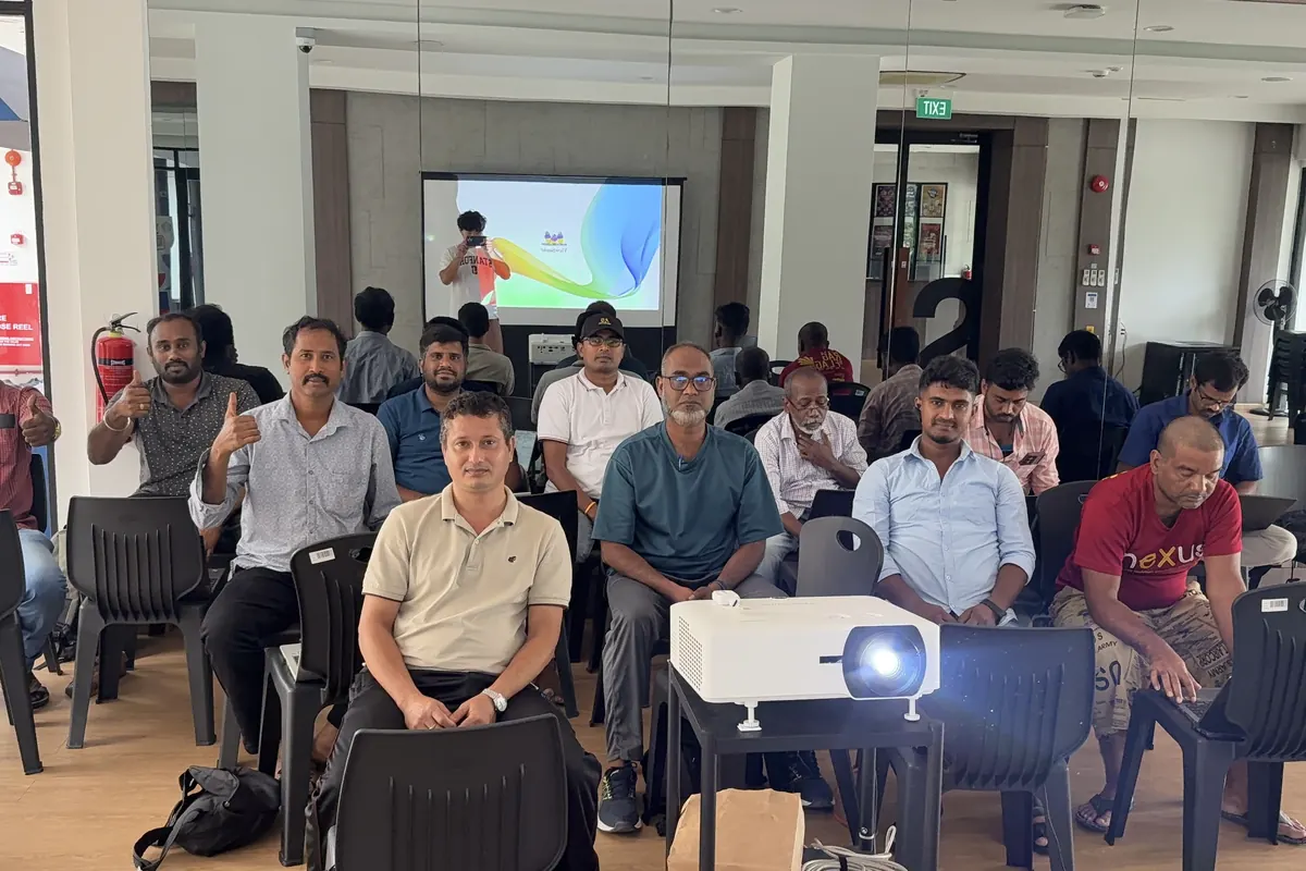 Course learners seated in rows behind a projector in the hall in Sembawang